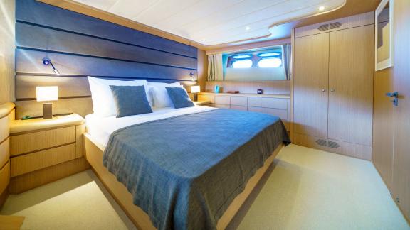 This guest cabin on Phantom yacht features a comfy bed and stylish natural lighting.