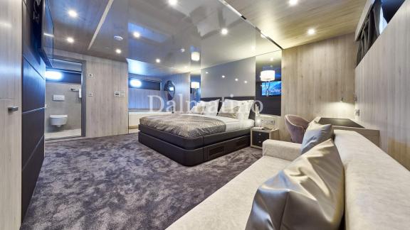 Großes und luxuriöses Hauptschlafzimmer auf der Dalmatino-Yacht mit Sofa, gemütlichem Bett und Ensuite-Bad.