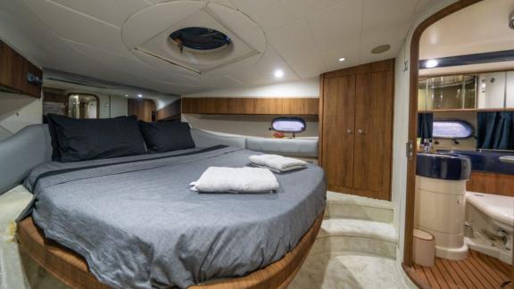 The master cabin of Karan motor yacht features a large bed and an en-suite bathroom for comfortable living.