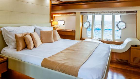 На Ferretti 780 Orlando L главная каюта с большими окнами и панорамным видом на море.