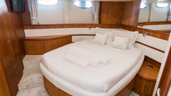 Die geräumige Hauptkabine der Yacht Drunken Sailor ist mit einem bequemen Bett und eleganten Holzakzenten ausgestattet.