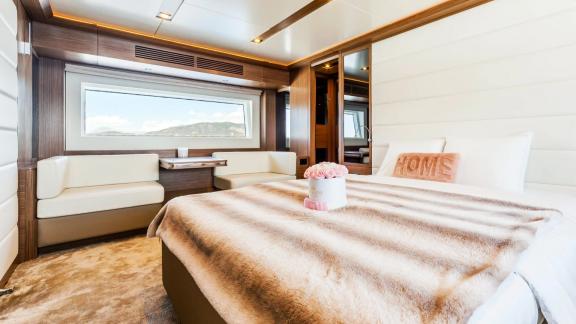 Large window, cozy bed, and seating area provide comfort on Sirena 64.
