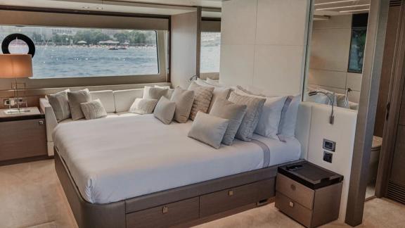 The master cabin of Lady M in Mallorca features a large bed, sea view window and bathroom access.