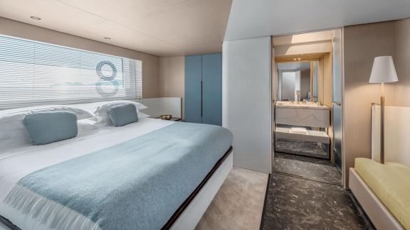 Großes Bett, Fenster mit Meerblick und Zugang zum Bad bieten luxuriösen Komfort.