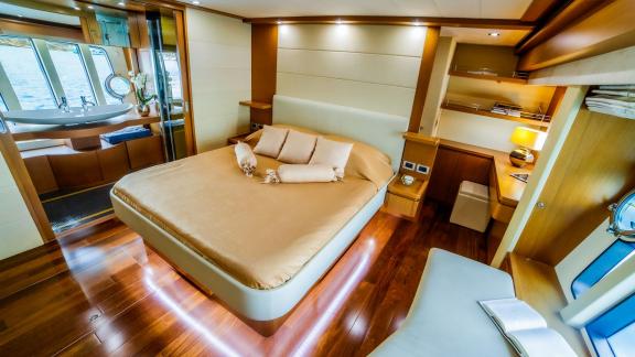 На моторной яхте Ferretti 780 Orlando L главная каюта с рабочей зоной и удобной кроватью.
