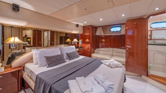 Komfortables Schlafzimmer der Motoryacht River S mit großem Bett und Sitzecke.