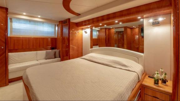 The master cabin of the Venus Secrets yacht offers a luxurious setting with a large bed and comfortable seating area.