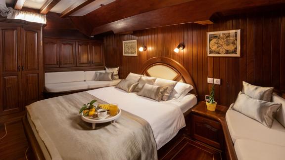 A spacious and luxurious cabin on board the gulet Nostra Vita in Croatia, equipped with a large bed and stylish furnishi