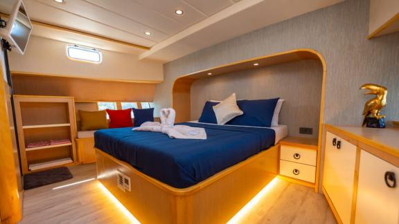 The master cabin of trawler yacht Kaan Bey 2 offers comfort with a large bed and modern decor.