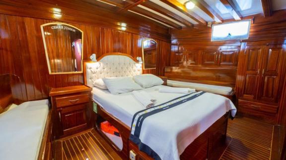 Double cabin of Gulet Cemre Junior with a large bed and wooden decor.