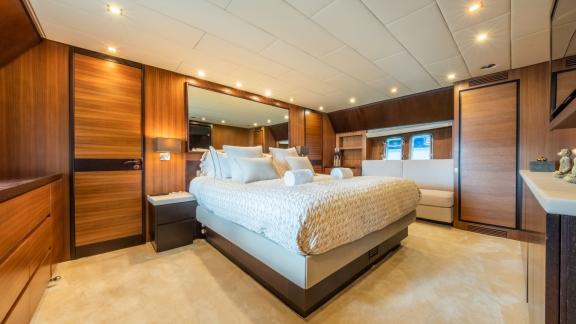 The luxurious master cabin on the motor yacht Aya One features a large bed, elegant decor, and a stylish seating area.