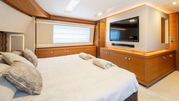 В мастер-каюте яхты Ferretti Navetta 28 установлен телевизор и большое окно с видом на море.