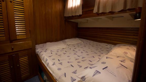 Gemütliche Kabine mit maritimem Bettbezug und Holzschränken auf der Gulet Erşen 1 in Bodrum.