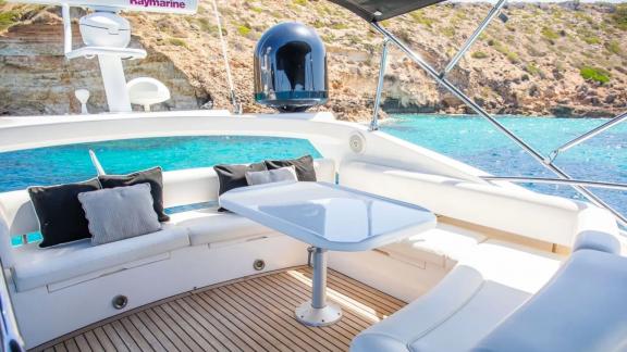 Comfortable seating area with a table on the flybridge of the yacht Midnight Summer Dream.