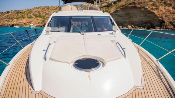 The foredeck of the motor yacht Midnight Summer Dream with a sunbathing area overlooking blue waters.