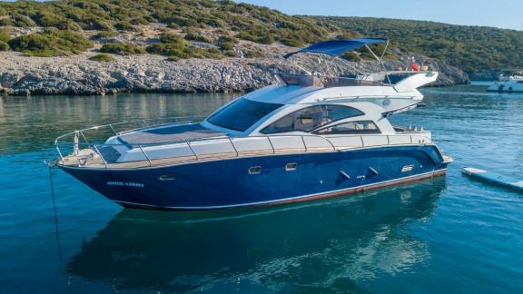 Motor yacht Moonlight is anchored in a beautiful bay, attracting attention with its elegant design.