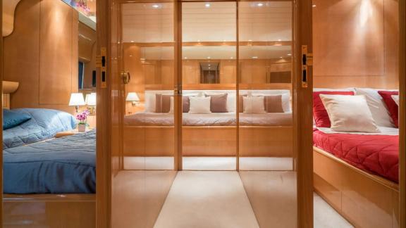 Zu sehen ist die Zweibettkabine der Motoryacht Atrato in Athen mit zwei Einzelbetten und Holzschränken.