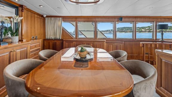 Among Cannes daily yacht rental options Ava motor yacht interior shows large dining table area.