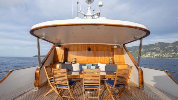 Among Cannes daily yacht rental options Ava motor yacht upper deck shows dining table and seating area.