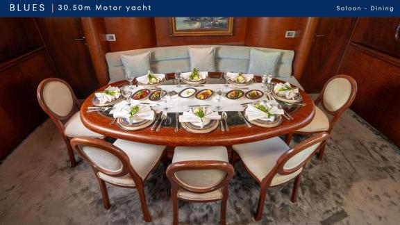 Geniş yemek masası zarif şekilde hazırlanmış. Salon bölümünde konforlu bir yemek ortamı sunuluyor.