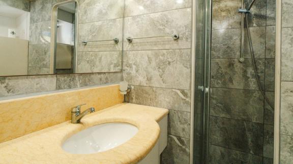 The Bona Dea motor yacht features marble style surfaces, a glass shower cabin and a spacious washbasin area.