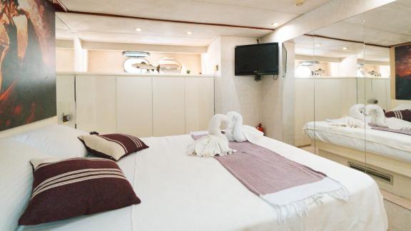 The Bona Dea motor yacht features a comfortable guest cabin with a double bed, mirrored wardrobes and a TV.