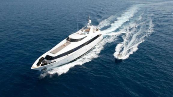 The luxury yacht Brooklyn sails swiftly through open waters, accompanied by a fast-moving jetski.