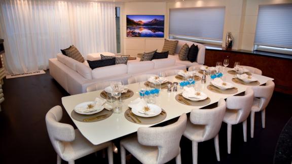 A modern dining setup paired with a spacious lounge in the yacht's stylish interior.