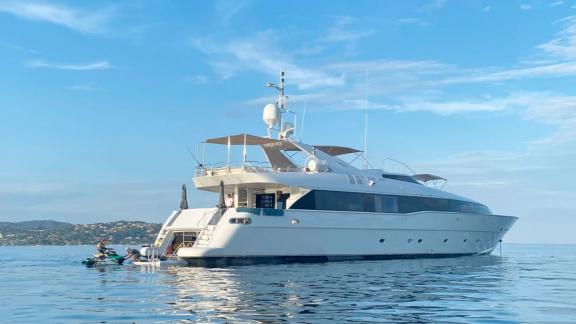 Anchored off Athens, the Brooklyn yacht features a swim platform where guests enjoy water activities.