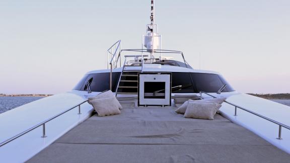 The foredeck of the Brooklyn yacht offers a cozy sunbathing spot with plush cushions and serene views.