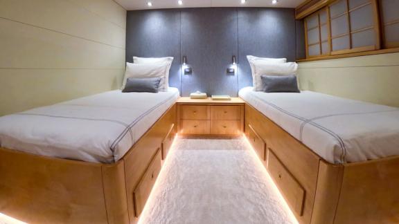 Cozy twin bed cabin with modern lighting and light wood design.