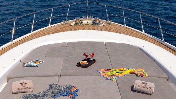 Onboard the Mangusta 108 Cosmos, lounge on sunpads with a drink and enjoy panoramic sea views in comfort.