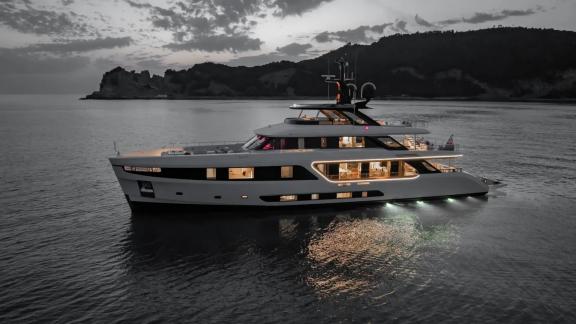 Dawo anchored near shore, glowing at night with elegant lighting on calm waters.