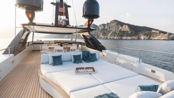 Spacious flybridge with sunbeds and dining area for relaxing moments on Dawo.