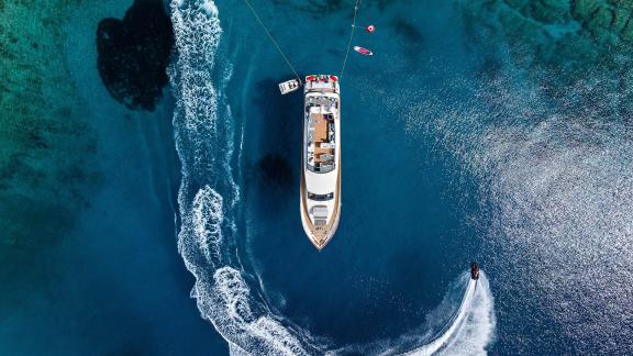 Top view of Dream motor yacht anchored in Athens with jet ski trails circling around.
