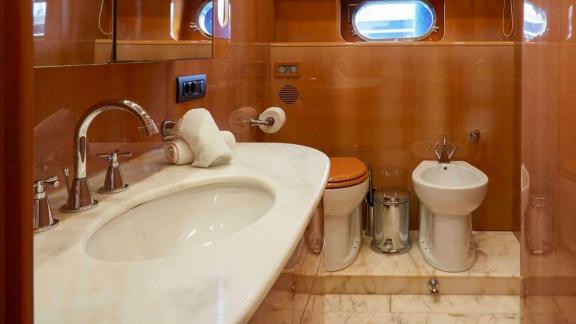 The bathroom of Dream motor yacht in Athens features a sink, toilet, bidet and marble flooring.