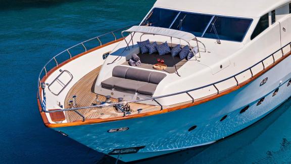 The foredeck of Dream motor yacht in Athens features a spacious sunbathing area with cushioned seating.