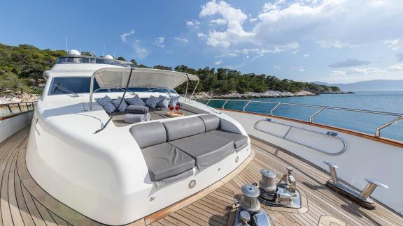 The foredeck of Dream motor yacht in Athens shows large sunpads with sea and coastline views.
