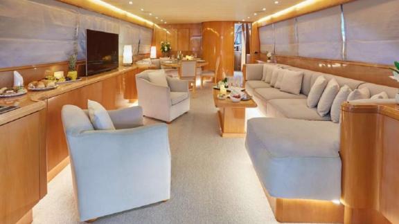 The main salon of Dream motor yacht in Athens features a large seating area, TV unit and dining table.