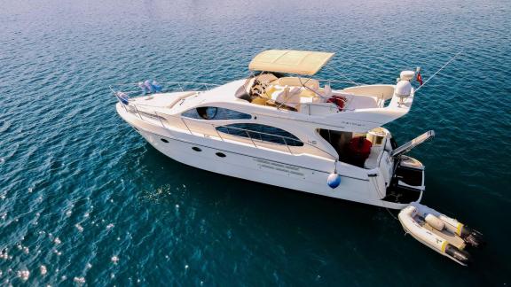 Side view of motor yacht Ela, featuring a spacious deck and elegant design.