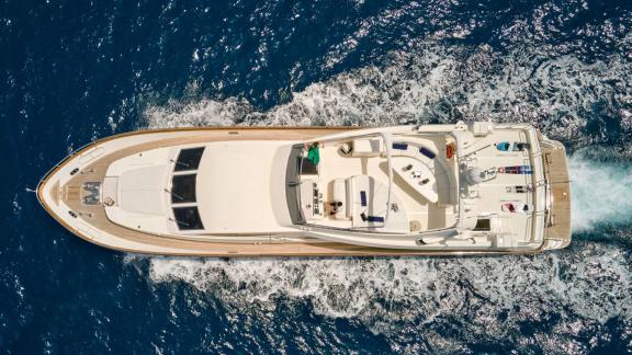 Off Athens the 4 cabin 10 guest motor yacht Estia Poseidon cruising. Aerial view with spacious deck.