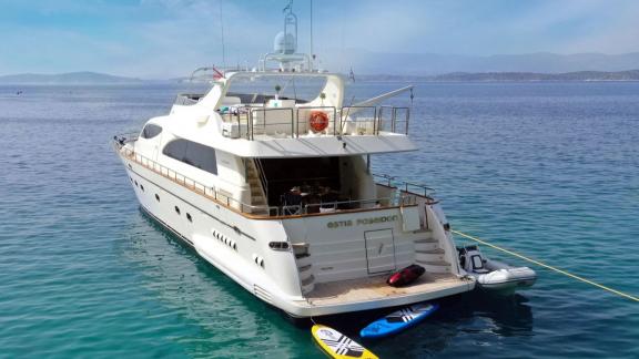 Anchored off Athens the 4 cabin 10 guest motor yacht Estia Poseidon is seen from the stern. Paddle boards and tender at