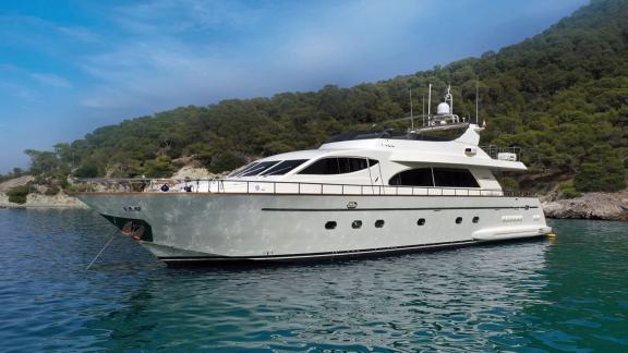 Anchored in an Athens bay the 4 cabin 10 guest motor yacht Estia Poseidon is shown from the side for yacht charter.