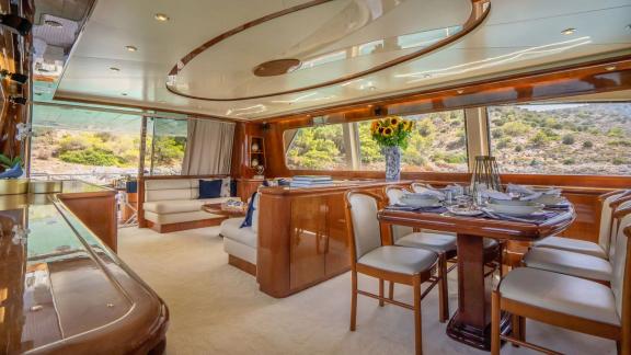 Off Athens the 4 cabin 10 guest Falcon 86 Estia Poseidon motor yacht features a refined saloon with dining area.