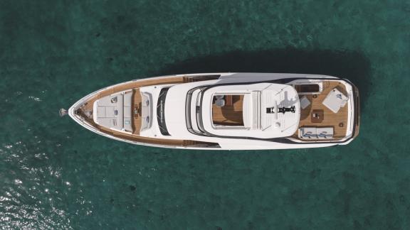 In Sibenik motor yacht charter option First Horizon aerial view resting on clear calm sea.