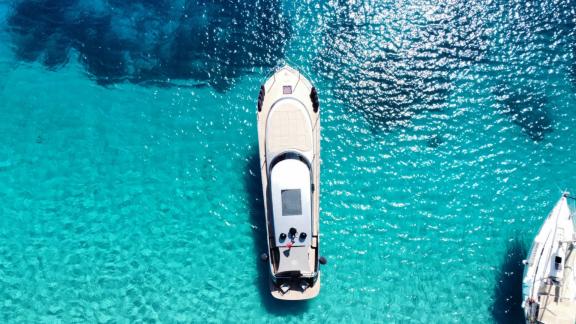 Motor yacht Fundamental B aerial view over turquoise waters.