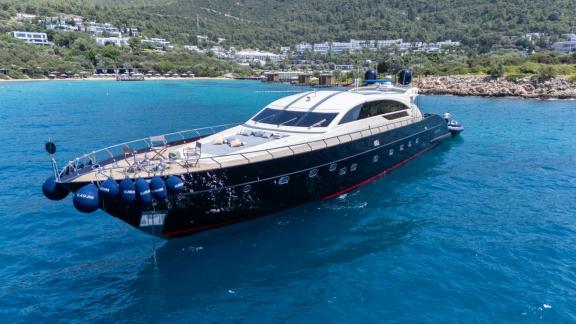 Роскошная моторная яхта Kayanni стоит на якоре в бирюзовых водах у берегов Бодрума.