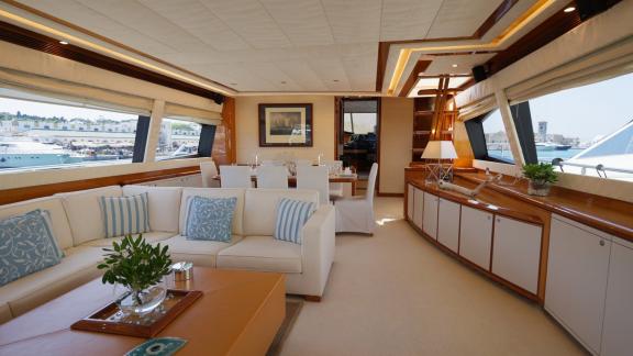 Among motor yacht rental options in Rhodes Lady Natassa interior shows seating area and dining table onboard.