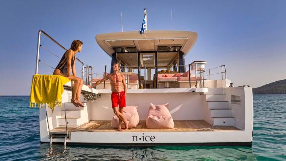 Anchored off Lavrion the 3 cabin 6 guest Omikron Yachts OT 60 N ice with aft platform lounge by the sea.