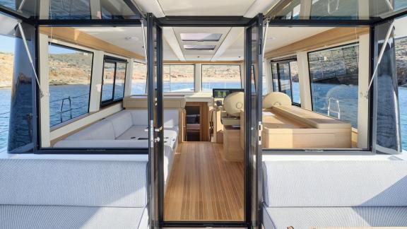 Off Lavrion the 3 cabin 6 guest Omikron Yachts OT 60 N ice showing saloon entrance with helm station and wide windows.
